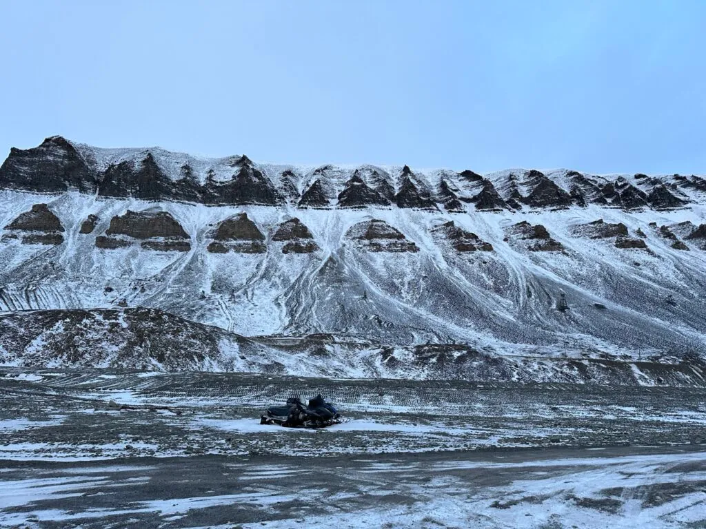 En ensom snøscooter venter på vinter og snø. 
