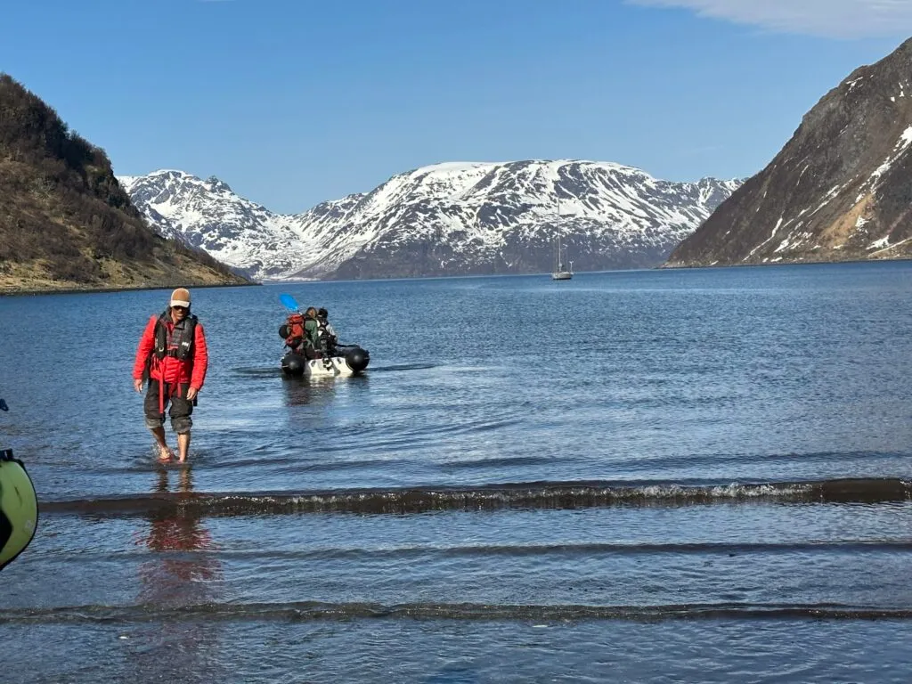 Guide Jordi Tosas wades onto the beach on a sunny morning. The water is ice cold so you'll be happy you brought waterproof rubber boots.